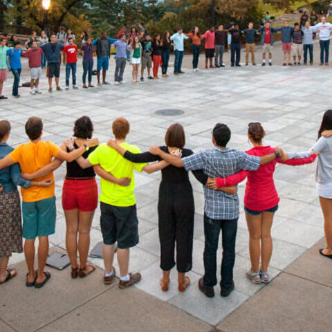 Group of people arm in arm in a circle