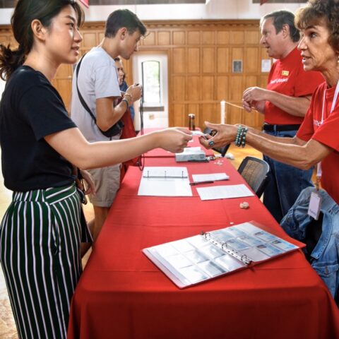 woman handing a student materials across a table