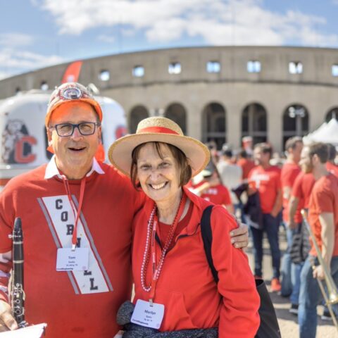 older couple in Cornell gear in front of football stadium