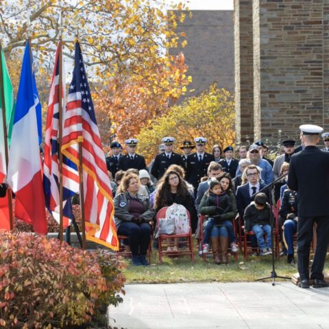 seated group of people with flags and military personnel